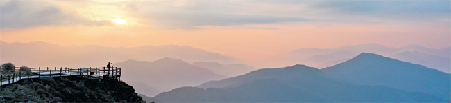 지리산 노고단 정상으로 향하는 목조 덱에 조성해 놓은 전망대. 여기 서서 고개를 들면 첩첩한 지리 능선이, 고개를 숙이면 지리산의 발치를 적시며 흘러가는 섬진강의 물굽이가 바라다보인다. 장엄한 일출을 기대했지만, 이날은 아침 해가 한 뼘쯤 떠오른 뒤에야 구름 사이로 모습을 드러냈다.