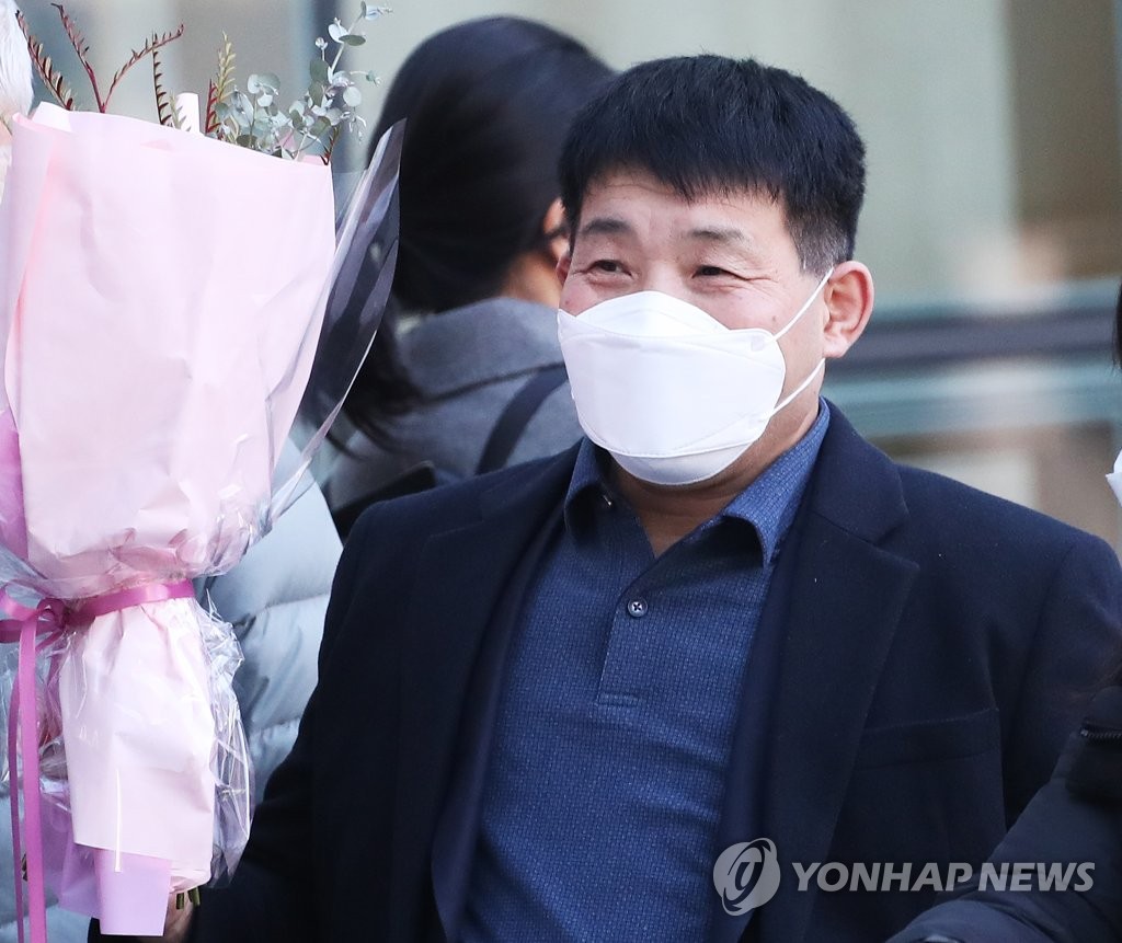 (수원=연합뉴스) 17일 오후 경기도 수원시 영통구 수원지방법원에서 열린 이춘재 연쇄살인 8차 사건 재심 선고공판에서 재심 청구인 윤성여 씨가 무죄를 선고받고 법원 청사를 나와 꽃다발을 받고 환하게 웃고 있다.