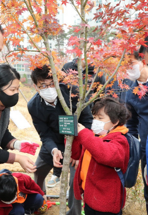 지난 11월 13일 서울 마포구 아현동에서 한 어린이가 ‘마을이 심는 숲’ 조성 행사에 참가해 기념 표찰을 달고 있다.