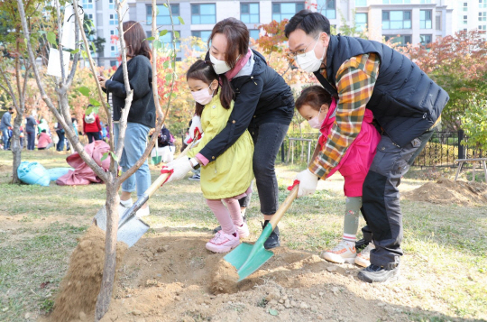 지난 10월 17일 서울 마포구 신수동에서 한 가족이 소중한 사연이 담긴 기념 나무를 심고 있다.  마포구청 제공