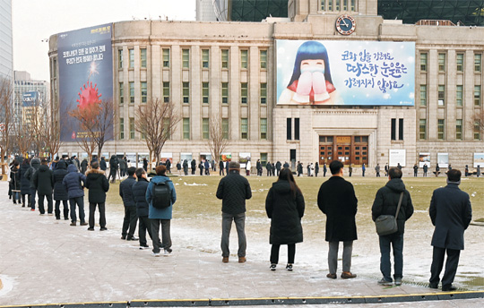 서울광장에 설치된 중구 임시선별진료소를 찾은 시민들이 18일 오전 강추위 속에서도 신종 코로나바이러스 감염증(코로나19) 진단검사를 받기 위해 장사진을 이루고 있다.