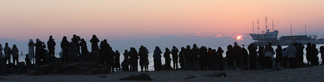 22일 오전 일출 명소인 강원 강릉시의 한 해변에서 관광객들이 해돋이를 감상하고 있다. 이날 정세균 국무총리는 신종 코로나바이러스 감염증(코로나19) 특별방역대책을 발표하고 “오는 24일∼내년 1월 3일 사이 인파가 몰리는 주요 관광명소 등을 과감하게 폐쇄할 것”이라고 말했다.   연합뉴스