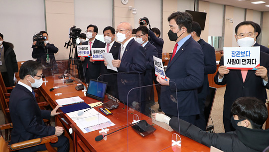 23일 국회에서 열린 변창흠(왼쪽) 국토교통부 장관 후보자에 대한 인사청문회에서 국민의힘 의원들이 변 후보자 앞에서 피켓을 들고 항의하고 있다.
