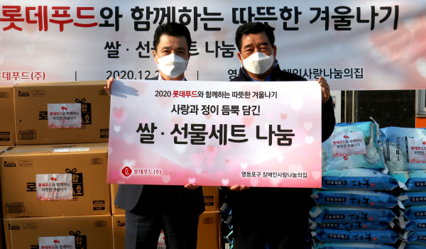 최인태(왼쪽) 롯데푸드 지원부문장이 22일 서울 영등포구 장애인사랑나눔의 집에서 김금상 장애인사랑나눔의 집 회장에게 저소득층 장애인 가구에 지원할 쌀과 로스팜 세트를 전달한 뒤 기념사진을 찍고 있다. 롯데푸드 제공