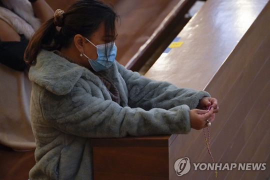 마스크를 쓴 채 크리스마스 미사에 참석한 미국 시민 [AP=연합뉴스]