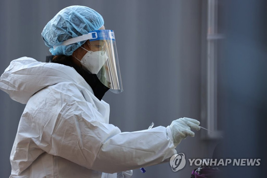 (서울=연합뉴스) 신종 코로나바이러스 감염증(코로나19) 신규 확진자가 1천200명대를 기록한 25일 오후 서울광장에 마련된 임시선별진료소에서 의료진이 검체채취를 하고 있다. 2020.12.25