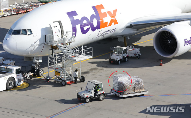 [인천공항=뉴시스]주한미군이 접종할 신종 코로나바이러스 감염증(코로나19) 백신을 싣은 특수 컨테이너(흰색)가 25일 오후 인천국제공항 화물터미널에 도착해 이송되고 있다. 2020.12.25.