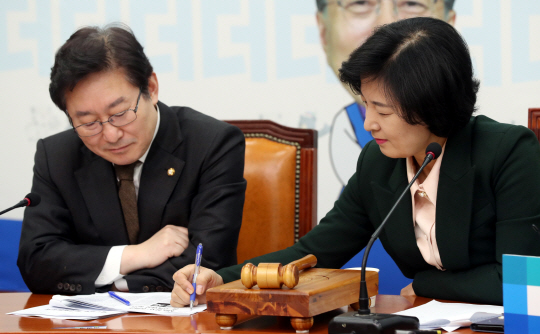 박범계(왼쪽) 더불어민주당 의원이 지난 2018년 1월 15일 국회에서 열린 최고위원회의에서 당시 당 대표였던 추미애 법무부 장관과 필담을 주고받고 있다.  뉴시스