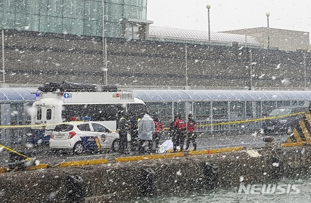 [제주=뉴시스] 31일 오전 제주항 3부두 터미널게이트 앞 해상에서 저인망어선 한림선적 32명민호(39t) 실종 선원으로 추정되는 시신을 발견해 해경이 신원확인 중에 있다. 해경이 신원확인을 위해 시신을 옮기고 있다. (사진=제주해경청 제공) 2020.12.31.