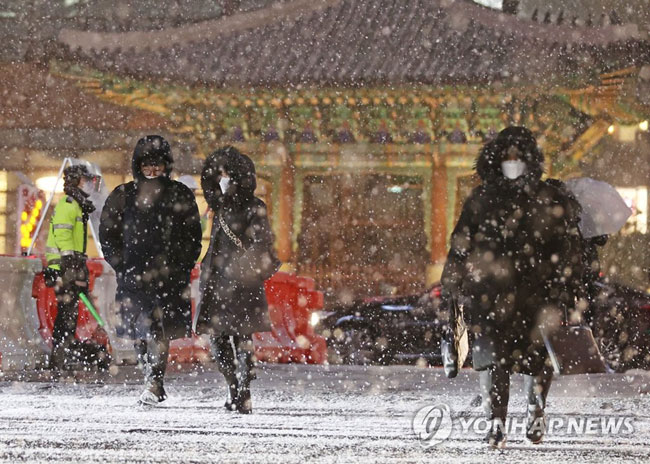 (서울=연합뉴스) 한종찬 기자 = 서울 전역에 대설주의보가 발효된 6일 저녁 서울 광화문역 인근에서 시민들이 퇴근길을 재촉하고 있다.