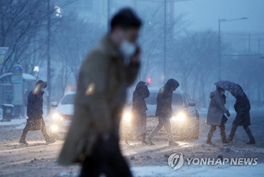(광주=연합뉴스) 광주·전남지역에 폭설·한파·강풍 특보가 동시에 발효된 7일 오전 광주 서구 도심에서 시민들이 힘겹게 출근하고 있다. 2021.1.7