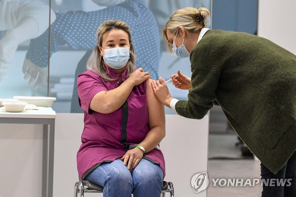 (베겔 AP=연합뉴스) 6일(현지시간) 네덜란드 베겔의 한 백신접종센터에서 요양원 간호사인 사나 엘카디리(왼쪽)가 이 나라에서 처음으로 미국 제약사 화이자와 독일 바이오엔테크가 공동 개발한 신종 코로나바이러스 감염증(코로나19) 백신을 접종받고 있다. 네덜란드는 유럽연합(EU) 27개 회원국 가운데 마지막으로 이날 코로나19 백신 접종을 시작했다.