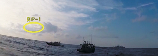 2019년 1월 광개토대왕함이 표류 중인 조난 선박에 대해 구조작전을 펼치는 가운데, 일본 초계기(원 안)가 저고도로 위협 비행을 하는 모습을 포착한 사진을 국방부가 공개했다.   뉴시스