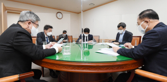 홍남기(오른쪽) 부총리 겸 기획재정부 장관이 13일 정부서울청사에서 열린 관계장관회의(녹실회의)에서 고용시장 상황을 점검하고 대응방향을 논의하고 있다.  지난해 연간 취업자 감소 폭이 21만8000명으로 22년 만에 최대로 나타나면서 문재인 정부가 표방하던 ‘일자리 정부’도 좌초 위기를 맞고 있다.  기획재정부 제공