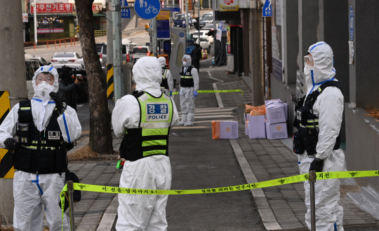 25일 오전 대전 중구 대흥동 IEM국제학교 앞에서 방호복을 입은 경찰관들이 출입을 통제하고 있다. 비인가 개신교 교육 시설인 이 학교에서는 전날 127명의 신종 코로나바이러스 감염증(코로나19) 확진자가 나왔다.  김낙중 기자