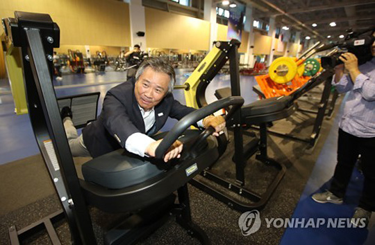 이기흥 대한체육회장이 충북 진천선수촌의 체력훈련장에서 운동기구를 살피고 있다.  연합뉴스