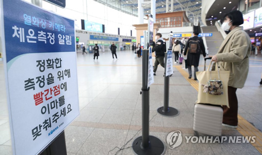 (서울=연합뉴스) 설 연휴 첫날인 11일 오전 서울역을 찾은 시민이 역 출입구에 있는 열화상 장비로 체온을 측정하고 있다. 2021.2.11