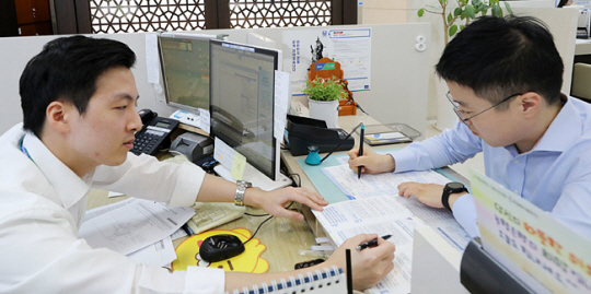 16일 오후 서울 중구 NH농협은행 본점 영업점에 마련된 ‘서민형 안심전환 대출’ 전담창구에 고객이 신청서를 작성하고 있다. 뉴시스