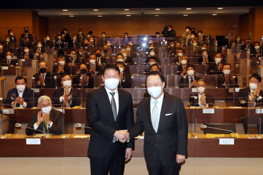 23일 서울상공회의소 의원총회에서 제24대 서울상의 회장으로 선출된 최태원(왼쪽) SK그룹 회장이 박용만 전임 회장과 악수하고 있다.
