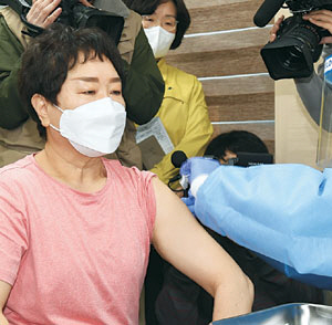 26일 오전 서울 노원구보건소에서 1호 접종자인 이경순(61) 요양보호사가 코로나 19 백신을 맞고 있다.  연합뉴스