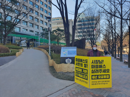 마을버스 사업자가 지난 24일 서울 중구 시청 서소문청사 앞에서 1인 릴레이 시위를 하고 있다.