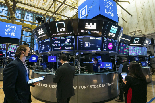 25일(현지시간) 미국 뉴욕증권거래소(NYSE) 플로어에서 트레이더들이 주가 추이를 지켜보면서 일하고 있다. 이날 증시는 미 국채 금리 급등 여파로 주요 지수가 큰 폭으로 하락했다. AP 연합뉴스