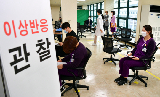 아스트라제네카(AZ) 백신 접종 후 사망 사례가 발생한 3일 오전 광주 동구 조선대병원 의성관에 설치된 호남권역 예방접종센터에서 화이자 백신 접종 대상인 의료진이 이상반응 관찰 대기 장소에 앉아 접종 순서를 기다리고 있다.  뉴시스