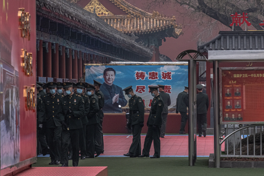 중국 연례 최대 정치행사인 양회(兩會·전국인민대표대회와 중국인민정치협상회의) 개막을 하루 앞둔 3일 행사장인 베이징 인민대회당 인근에서 시진핑 국가주석의 모습이 담긴 표지판 앞에 군인들이 집결해 있다. EPA 연합뉴스