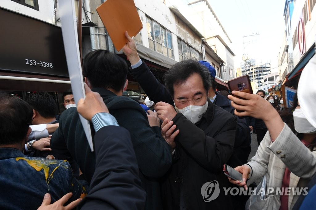 (춘천=연합뉴스) 더불어민주당 이낙연 대표가 5일 오후 강원 춘천시 중앙시장을 방문하던 도중 레고랜드 반대 단체 관계자가 달걀을 던져 몸을 피하고 있다. 2021.3.5