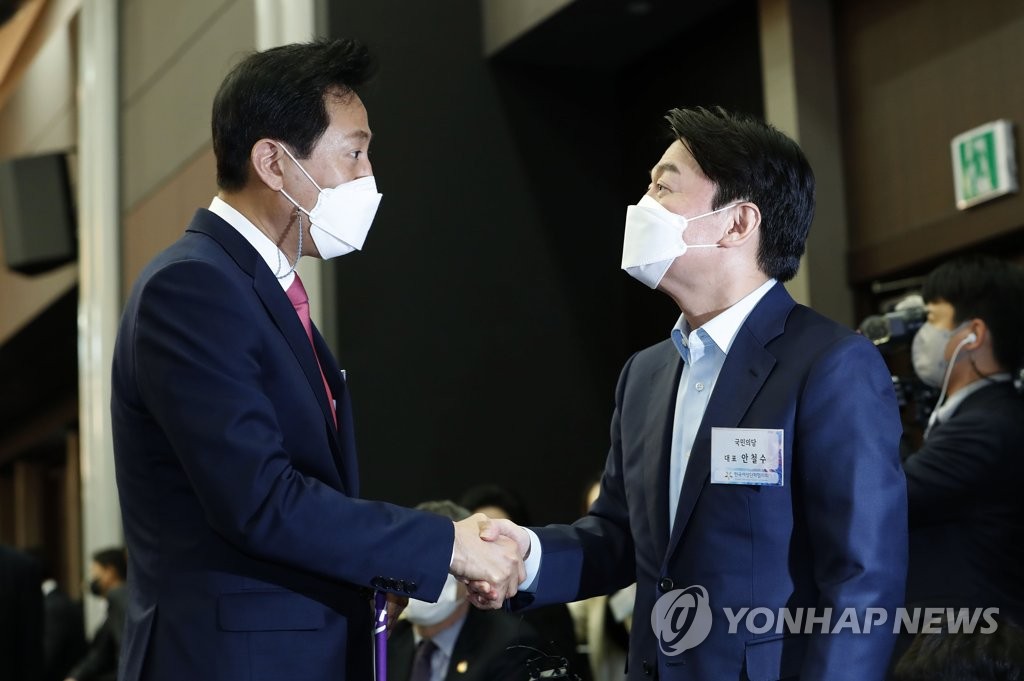 (서울=연합뉴스) 국민의힘 오세훈 서울시장 후보(왼쪽)와 국민의당 안철수 서울시장 후보가 8일 오후 서울 영등포구 공군호텔에서 열린 제113주년 3·8 세계 여성의 날 기념식에서 악수하고 있다. 2021.3.8 [국회사진기자단]