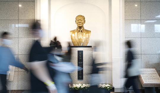 지난 15일 서울 송파구 서울아산병원 동관 1층에 있는 고 정주영 현대 명예회장 흉상 앞으로 환자들이 오가고 있다.  아산사회복지재단 제공