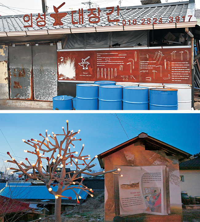 의성읍의 문 닫은 성냥공장과 의성전통시장을 잇는 골목에는 마을미술프로젝트로 설치한 미술작품이 곳곳에 있다. 사진 위는 대장간 내력을 적은 인터뷰를 걸어놓은 의성전통시장의 대장간. 사진 아래는 성냥을 형상화해 만든 나무에 불이 들어온 모습. 성냥공장으로 이어지는 주택가 골목에 있다.