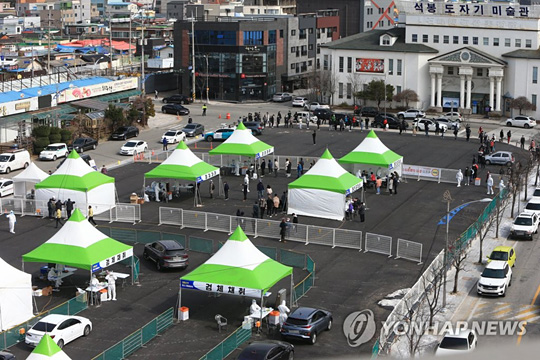 (속초=연합뉴스) 속초시민을 대상으로 하는 신종 코로나바이러스 감염증(코로나19) 전수검사가 진행된 18일 석봉도자기미술관 앞 공영주차장에 설치된 검사소에서 드라이브스루와 워킹스루 방식으로 검체채취 작업이 진행되고 있다. 2021.3.18