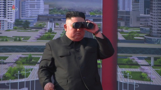 김정은 북한 국무위원장이 지난 23일 평양에서 열린 주택 1만 가구 건설 착공식에서 망원경으로 현장을 살펴보고 있다.  조선중앙TV·연합뉴스