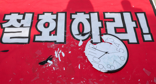 24일 국회 앞에 당구장 업주들이 오후 10시 영업제한 철회를 촉구하기 위해 부숴놓은 시계가 놓여 있다.  연합뉴스