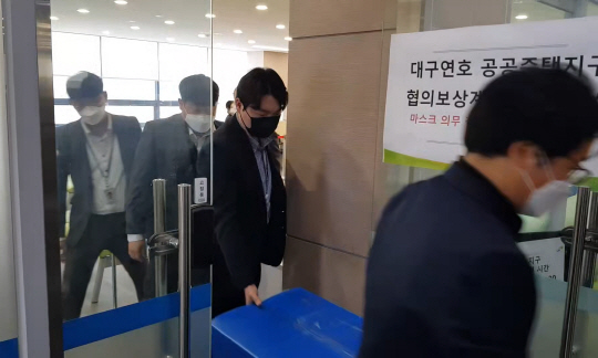 경찰이 1일 경북 경산시 한국토지주택공사(LH) 대구경북지역본부 대구 동부권 보상사업단 사무실을 압수수색해 연호공공주택지구 투기 의혹과 관련된 서류 등 압수물품을 들고나오고 있다.  연합뉴스