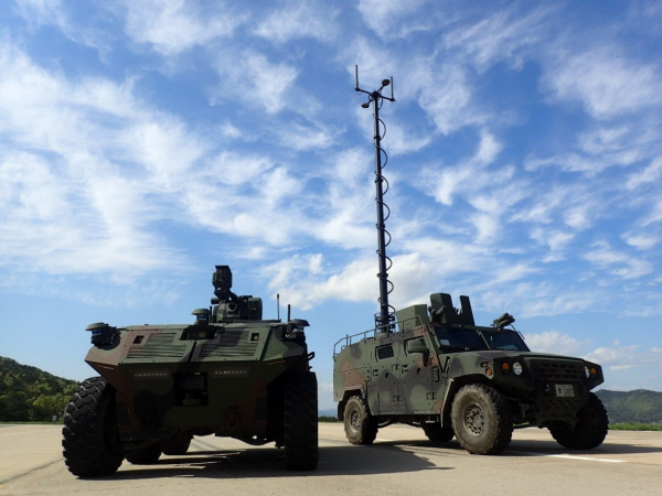무인차량(왼쪽)과 통제차량(오른쪽). 원격운용능력 향상을 위해 통제차량에 설치된 통신용 안테나를 길게 뻗은 모습. 방위사업청 제공