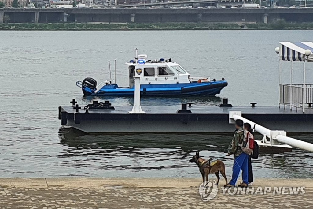 (서울=연합뉴스) 이미령 기자 = 30일 오후 서울 반포한강공원에서 엿새 전 실종된 대학생의 시신을 발견한 민간구조사가 구조견과 함께 시신 수습현장을 지키고 있다.
