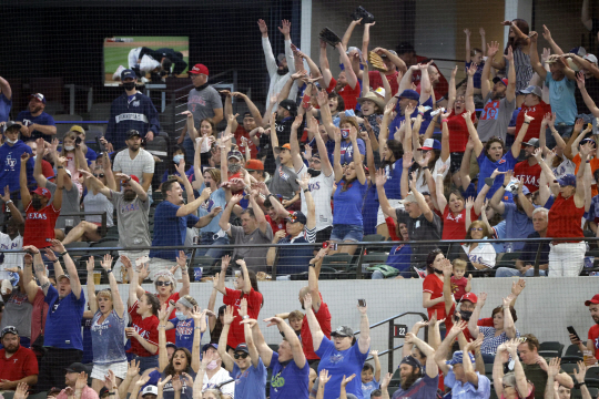 10일(한국시간) 미국 텍사스주 알링턴의 글로브라이프필드 관중석을 가득 메운 야구팬들이 시애틀 매리너스와의 경기 도중 파도타기 응원을 펼치고 있다.   AP연합뉴스
