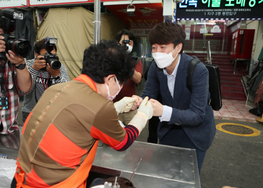 국민의힘 당 대표 경선에 출마한 이준석(오른쪽) 전 최고위원이 24일 오전 대구 중구 서문시장에서 상인과 주먹 인사를 하고 있다. 연합뉴스
