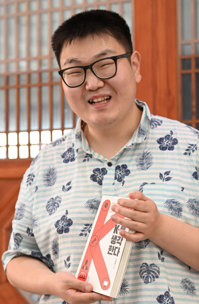 문화일보·예스24가 공동 진행하는 ‘국민 서평 프로젝트-읽고 쓰는 기쁨’의 첫 회 선정 도서인 ‘K-를 생각한다’를 쓴 임명묵 작가가 2일 서울역에서 책을 들고 포즈를 취하고 있다. 김낙중 기자