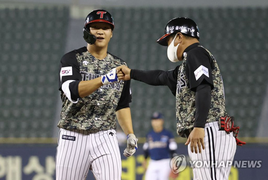 (서울=연합뉴스)  8일 서울 잠실야구장에서 열린 2021 KBO리그 NC 다이노스와 LG 트윈스의 경기. 8회말 2사 3루 LG 문보경이 1타점 역전타를 치고 김호 코치와 하이파이브를 하고 있다. 2021.6.8
