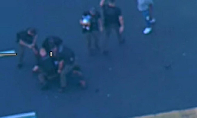 경찰이 제임스를 체포하는 장면. 화면 중간에 경찰이 오른 팔로 아기를 안은 모습이 보인다. [인디언리버 카운티 경찰 페이스북 갈무리]