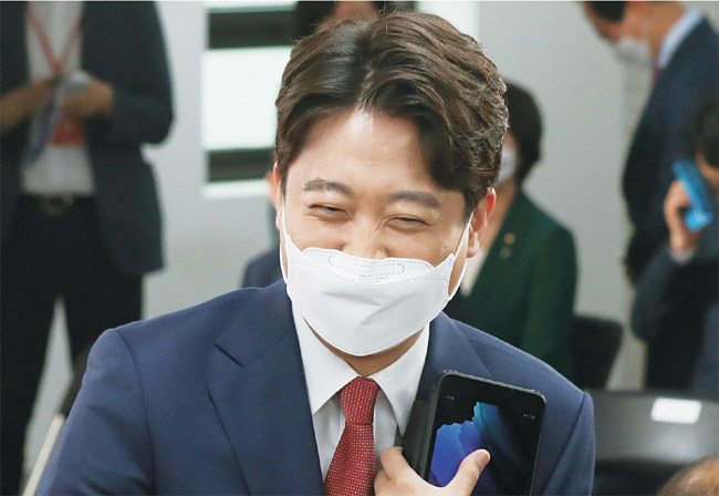 이준석 신임 국민의힘 대표가 11일 오전 서울 영등포구 여의동 당사에서 열린 국민의힘 전당대회에서 참석자와 인사하며 웃고 있다.  김낙중 기자