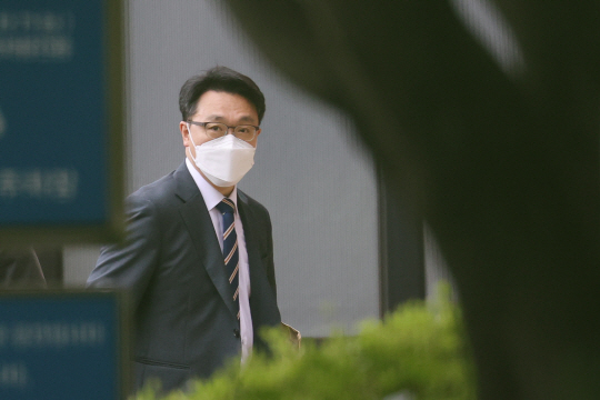 김진욱 고위공직자범죄수사처장이 11일 오전 경기 정부과천청사 공수처로 출근하면서 윤석열 전 검찰총장에 대한 직무유기 등에 대한 수사착수 배경을 묻기 위해 기다리고 있는 취재진을 쳐다보면서 건물 안으로 들어가고 있다.  연합뉴스