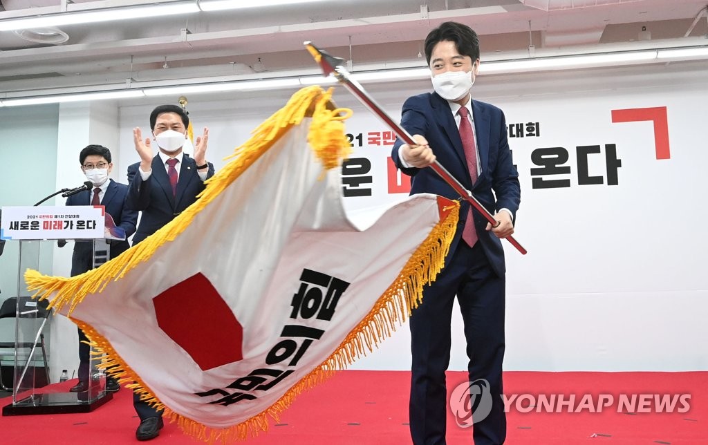 (서울=연합뉴스) 안정원 기자 = 국민의힘 이준석 새 당 대표가 11일 서울 여의도 중앙당사에서 열린 전당대회에서 당기를 흔들고 있다. 2021.6.11