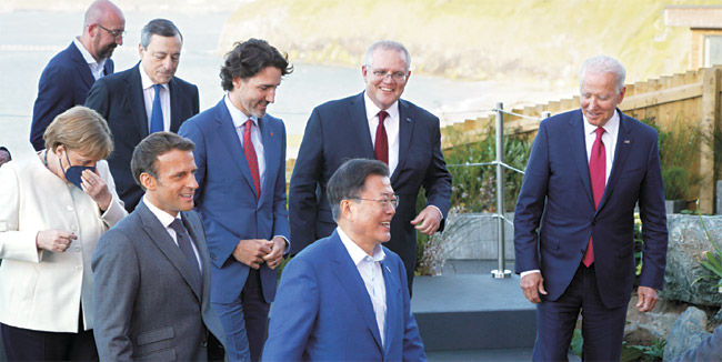 주요 7개국(G7) 정상회의 참석차 영국을 방문했던 문재인 대통령이 12일(현지시간) 영국 콘월 회담장 앞에서 참가국 정상들과 기념사진을 촬영한 후 활짝 웃으며 이동하고 있다. 앞줄 왼쪽부터 독일 앙겔라 메르켈 총리, 프랑스 에마뉘엘 마크롱 대통령, 문 대통령. 뒷줄 왼쪽부터 샤를 미셸 EU 정상회의 상임의장, 이탈리아 마리오 드라기 총리, 캐나다 쥐스탱 트뤼도 총리, 호주 스콧 모리슨 총리, 미국 조 바이든 대통령. 연합뉴스