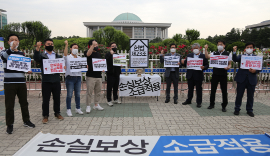 손실보상법 입법의 피해 업종 중소상공인·시민단체 관계자들이 지난 7일 서울 여의도 국회 앞에서 손실보상 소급적용을 촉구하는 시위를 벌이고 있다.  연합뉴스