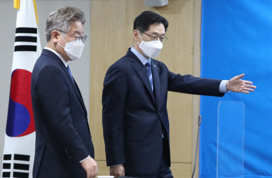 이재명(왼쪽) 경기지사가 17일 오전 경남 창원시 경남도청에서 열린 ‘경기도-경상남도 공동발전을 위한 정책 협약식’에서 김경수 경남지사의 안내를 받고 있다.  연합뉴스