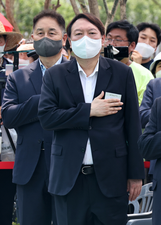 윤석열(앞쪽) 전 검찰총장이 지난 9일 서울 중구 남산예장공원에서 열린 우당기념관 개관식에 참석해 국민의례를 하고 있다.  연합뉴스